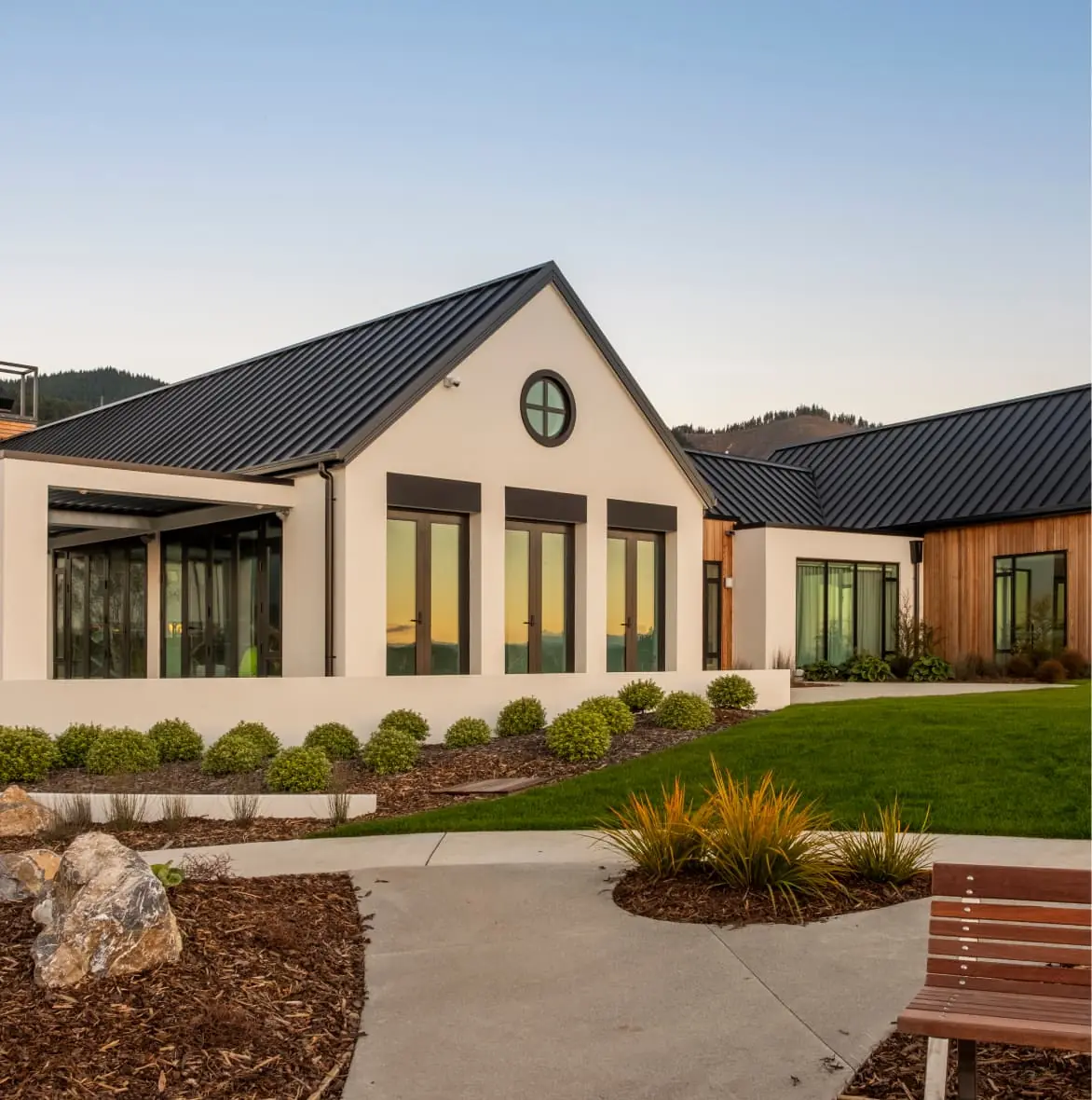 Modern architectural design of olive estate lifestyle village building in richmond, new zealand with landscaped gardens.