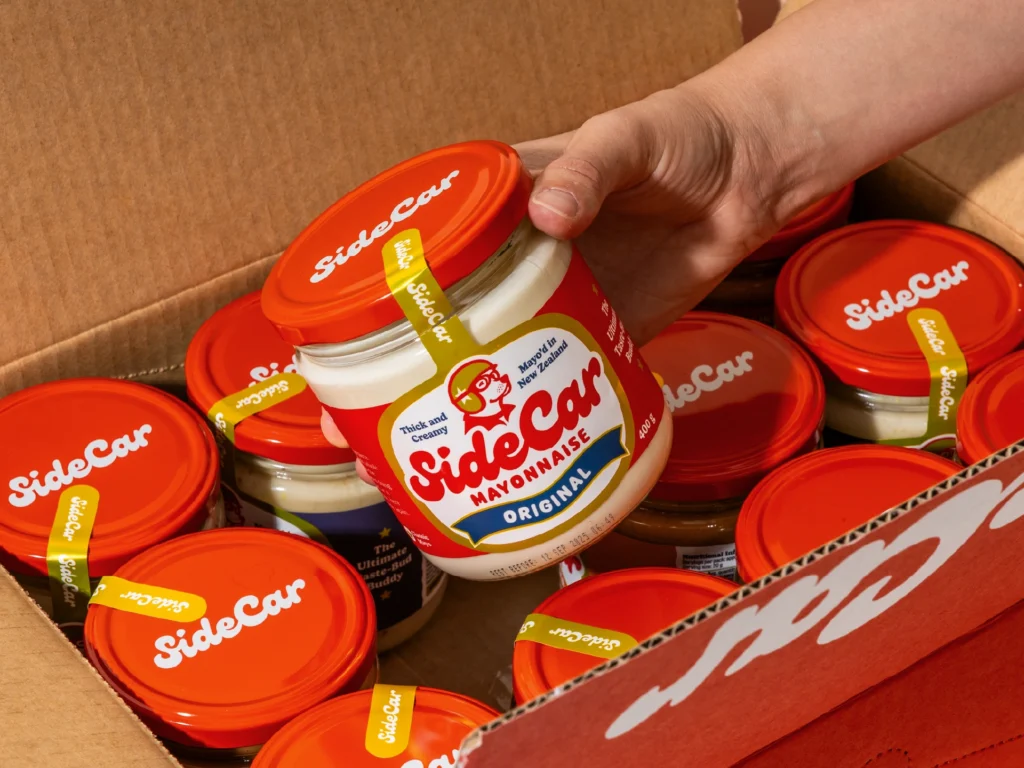 Hand holding jar of mayonnaise.