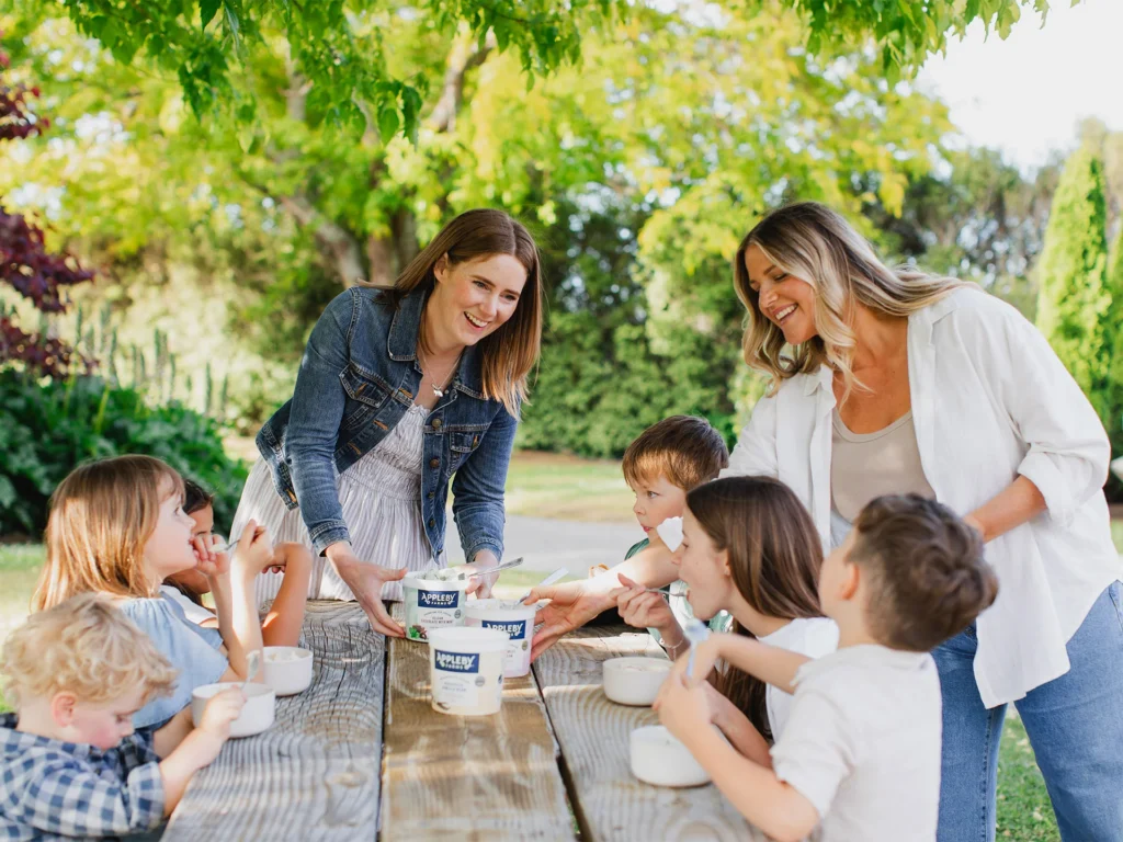 Children enjoying ice cream outdoors together.
