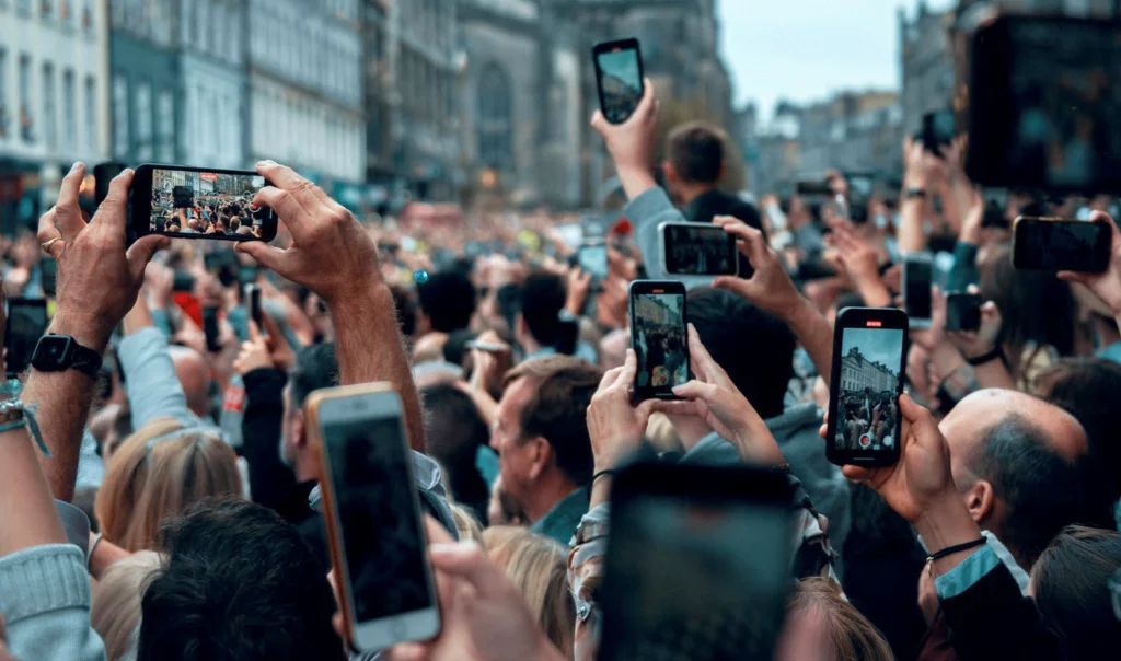 Brand fame and mental availability drives market reach and consideration - crowd capturing moments with smartphones