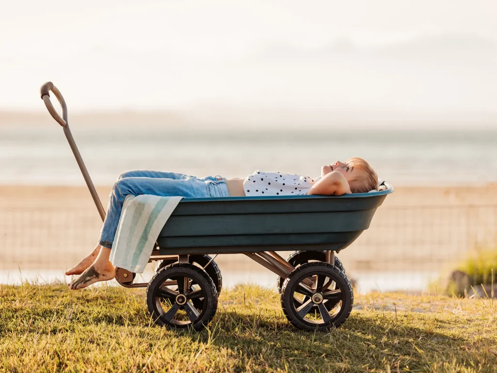 Child relaxing in a trolley outdoors.