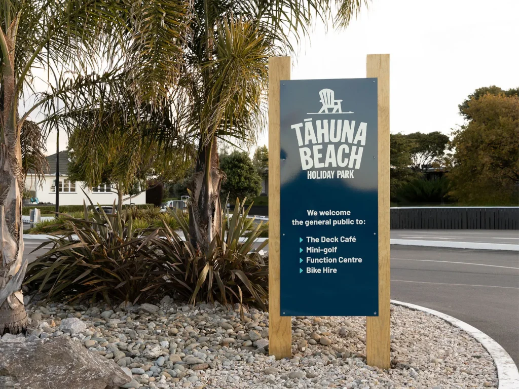 Tāhuna Beach Holiday Park brand on entrance sign