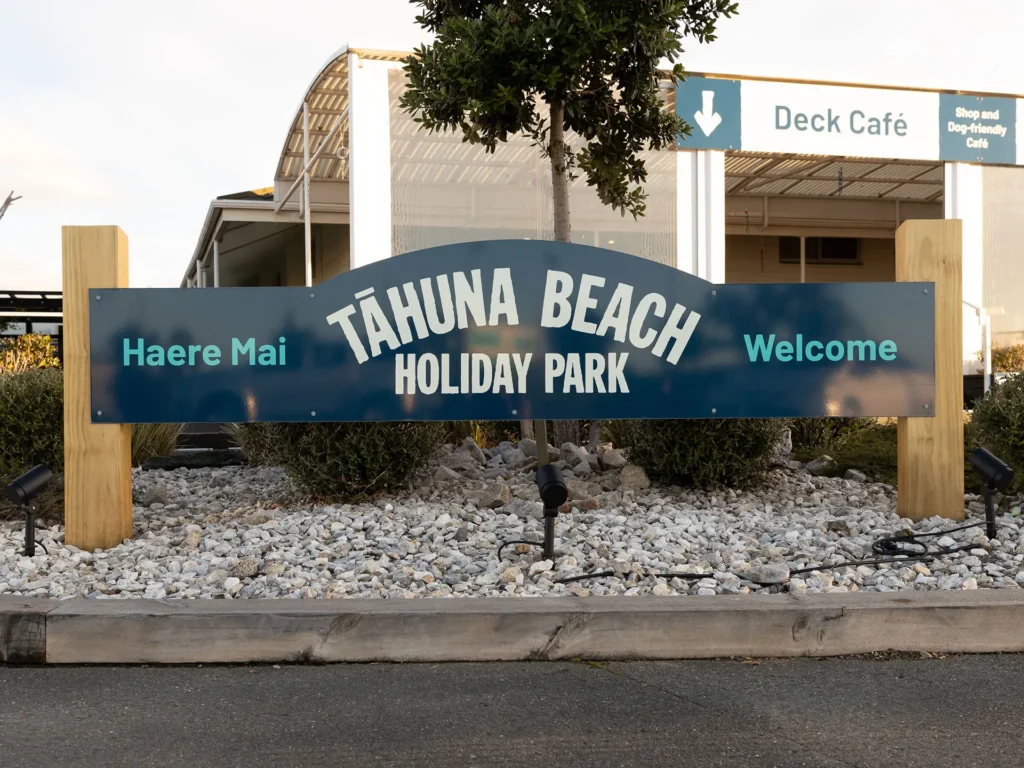 Tāhuna Beach Holiday Park brand on entrance sign